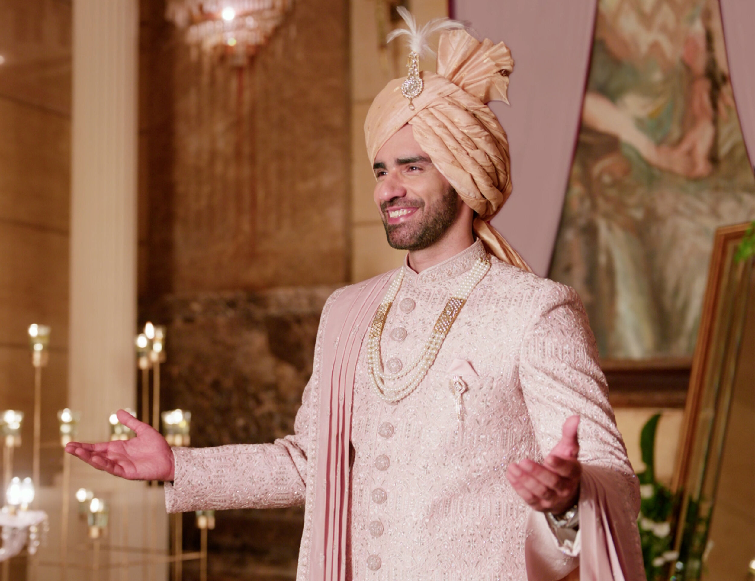 Refined shell white sherwani featuring a classic gold brooch, enhancing the groom's wedding look